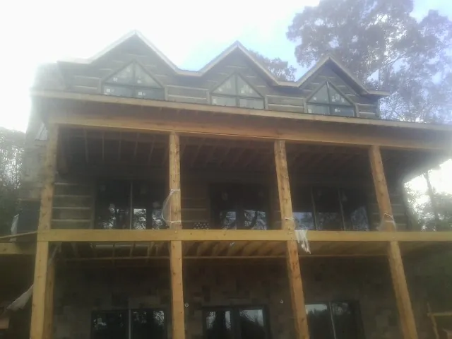 Dormers and porch framing on a large log home under construction — Roof Coating work by our crew in West Chicago